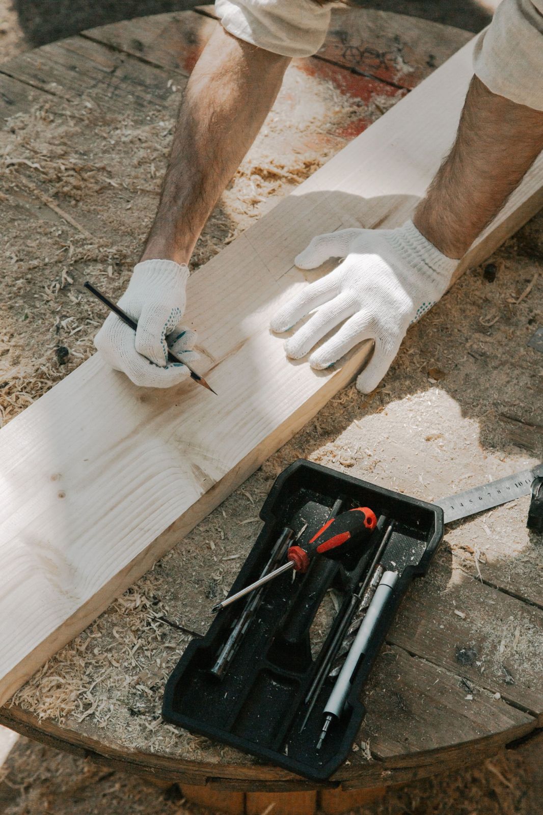 Carpenter marking a wooden board with a pencil