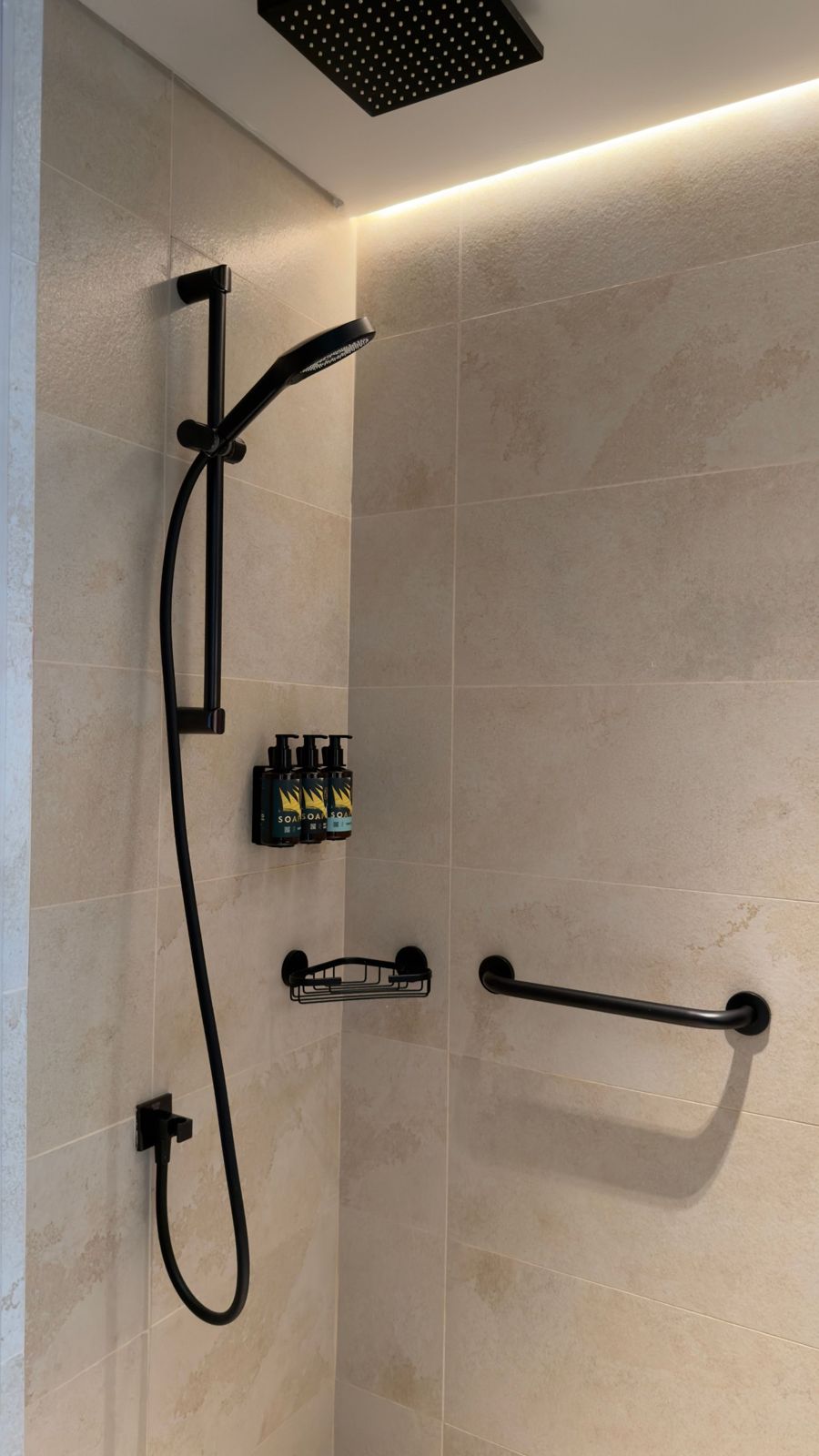 Shower with beige stone-effect tiles and matt black fittings